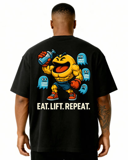 „Oversized Pumpcover T-Shirt schwarz – Cartoon Lifter mit Pac-Man Style Cheat Meal Ghosts und Eat Lift Repeat Slogan“