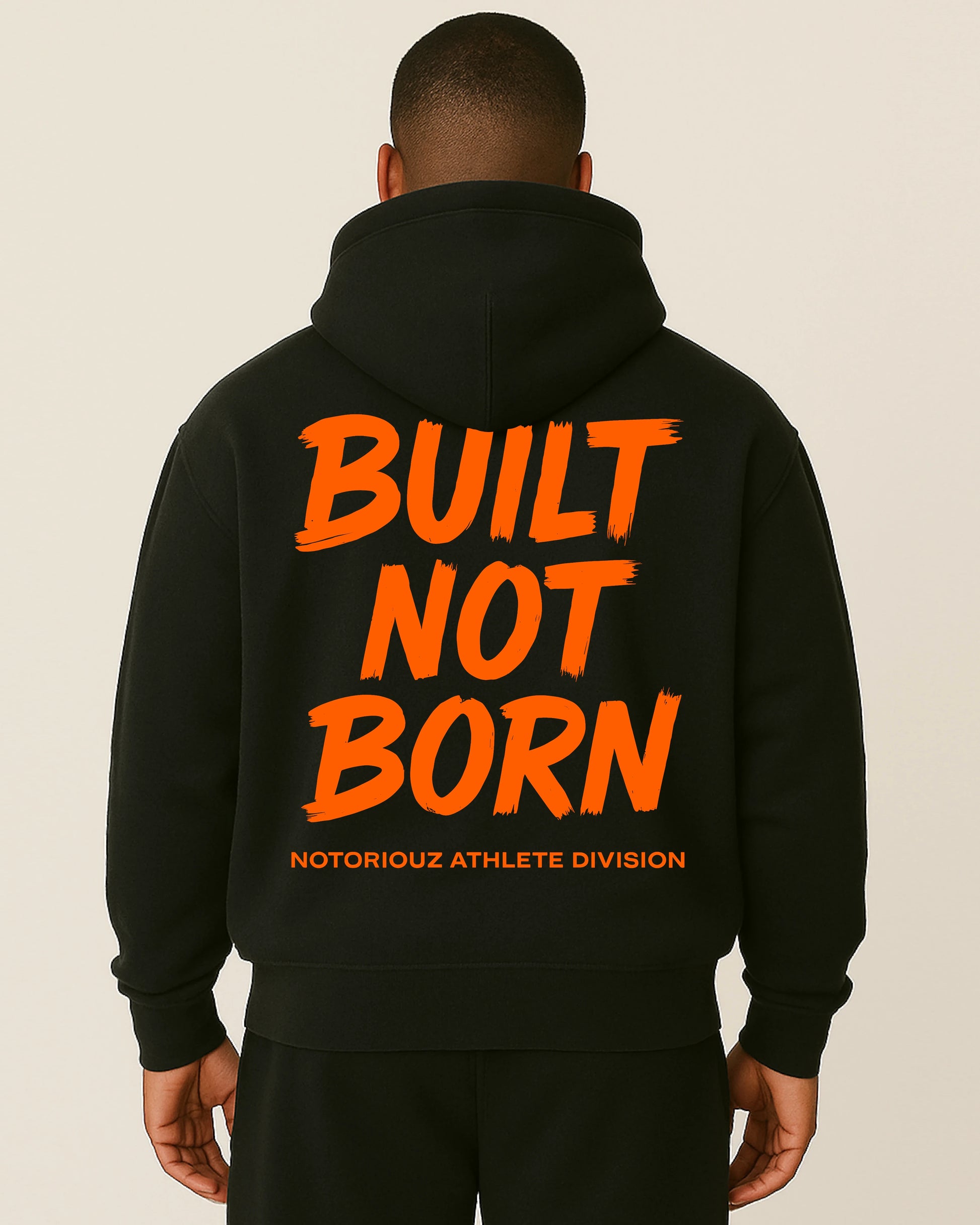 “Rückansicht eines schwarzen Notoriouz Sportswear Hoodies mit orangem BUILT NOT BORN Print aus der IRON GENESIS Kollektion.”