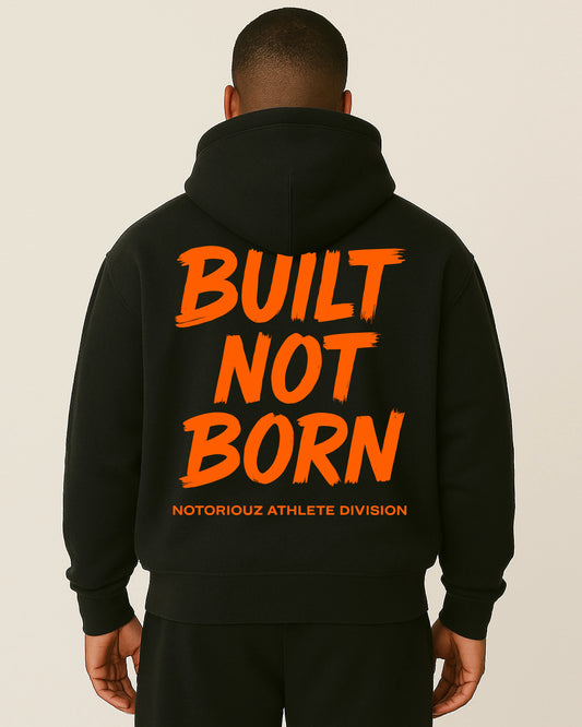 “Rückansicht eines schwarzen Notoriouz Sportswear Hoodies mit orangem BUILT NOT BORN Print aus der IRON GENESIS Kollektion.”